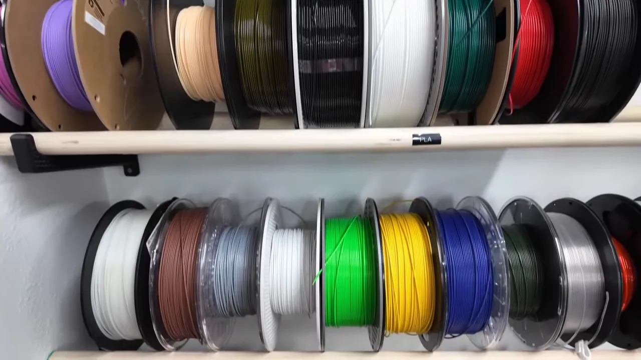 rows of colorful 3D printer filament spools neatly stored on a rack