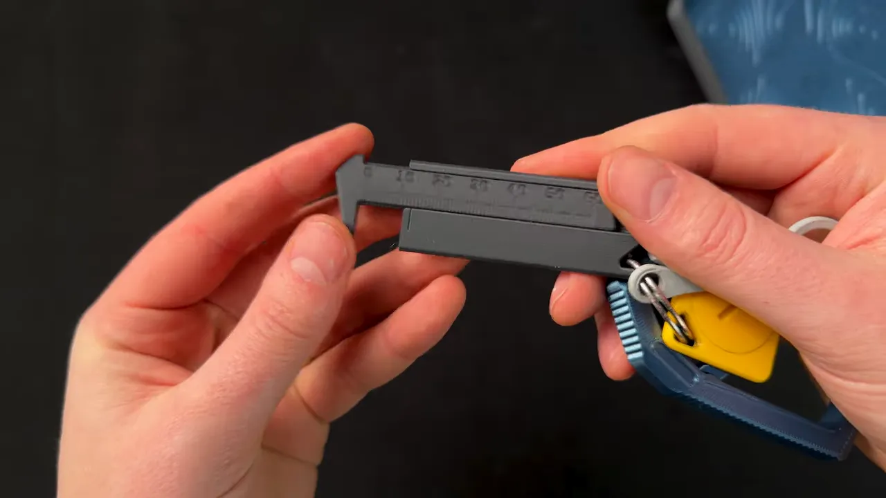 Close-up of 3D printed keyring calipers measurement scale in hands