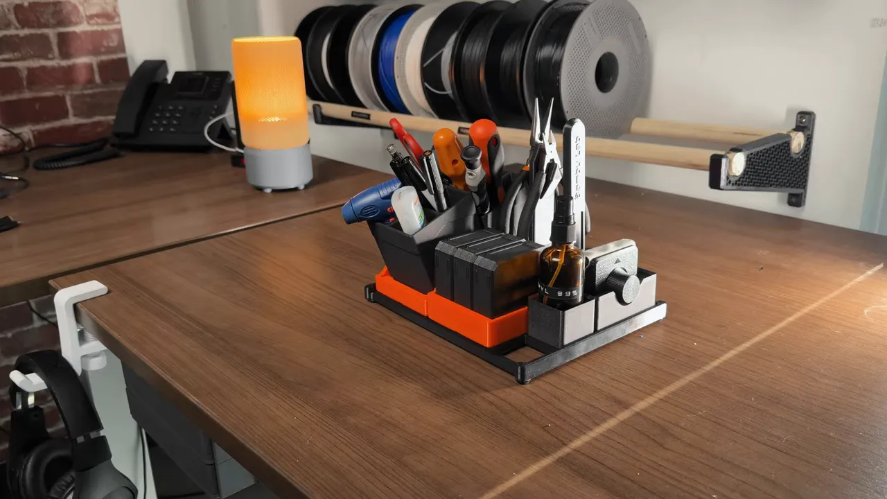 3D printed desktop organizer with tools and filament spools on a wooden desk