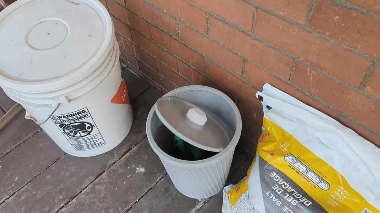 white outdoor buckets and a small grey bin beside a brick wall on a wooden porch