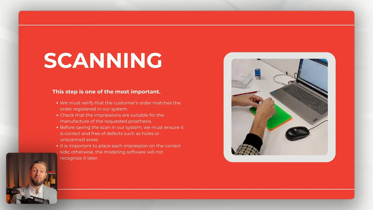 Hands positioning an ear impression on a green work pad next to a laptop, ready for scanning.