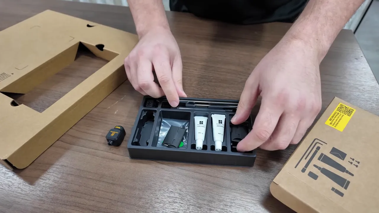Sharp close-up of the Bambu P2S accessory kit laid out: lubricant tubes, tool bits and small components