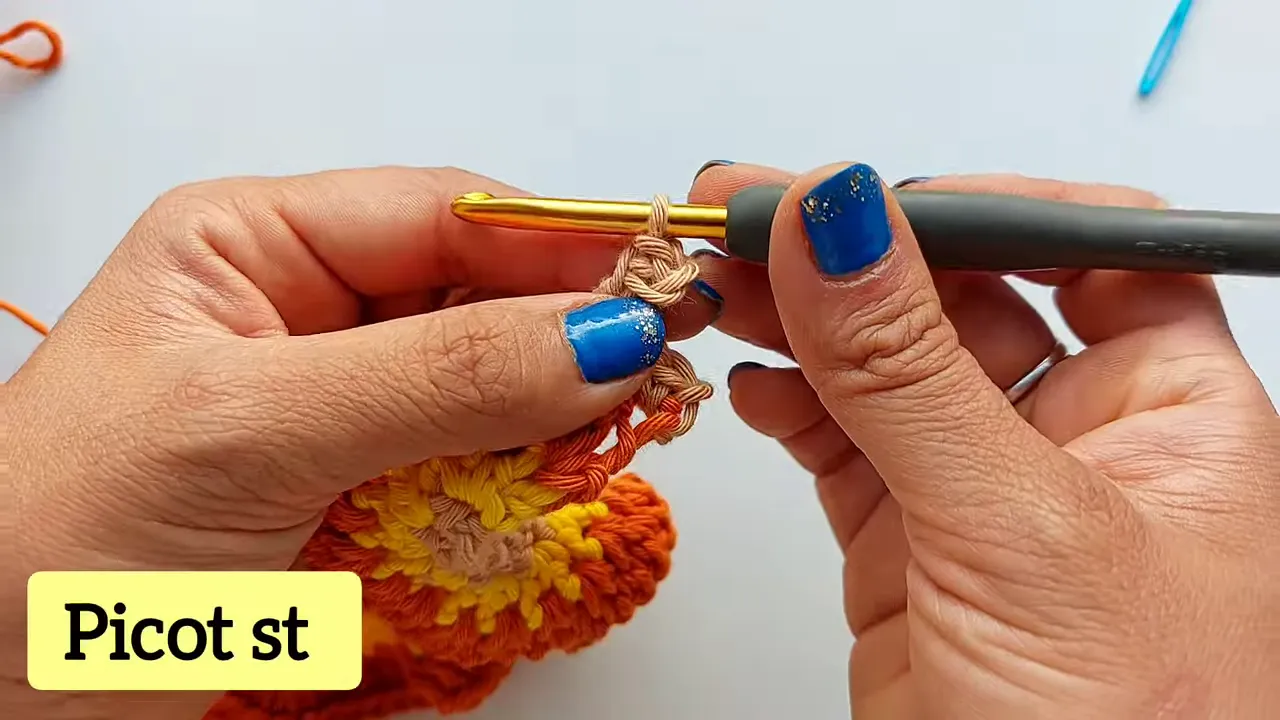 Close-up of a beige picot stitch along the edge of an orange and yellow crochet spiral