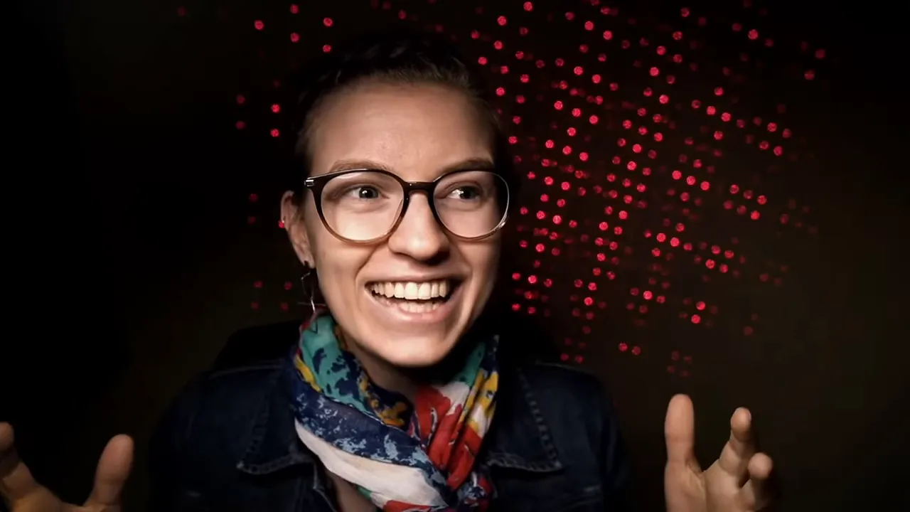 Presenter smiling and gesturing during explanation with red dotted background
