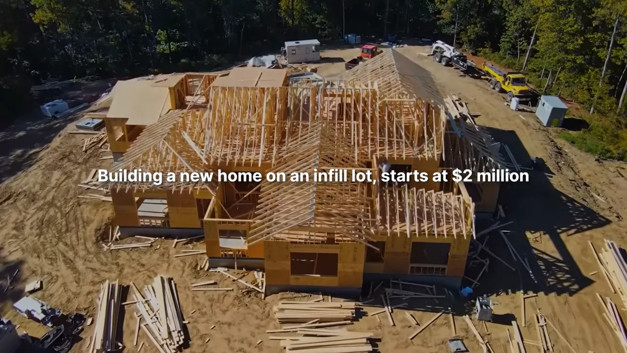 Aerial view of a new home under construction with framing across the lot