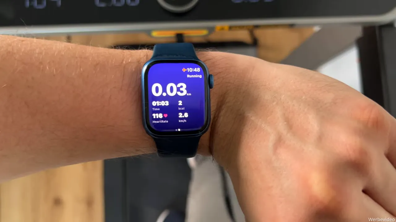 Apple Watch am Handgelenk zeigt Herzfrequenz und Trainingsdaten während der Nutzung des WalkingPad X214