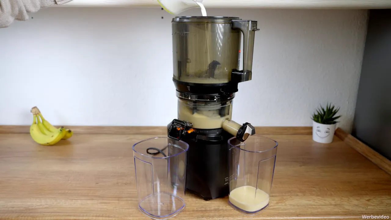 Kuvings AUTO10S: Milch wird in den Hopper gegossen und cremiger Smoothie fließt in den Auffangbehälter.