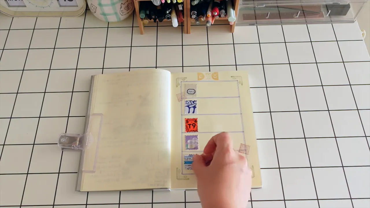 切手型クラフトパンチで抜いた紙片を日記ページ上で位置合わせしている様子