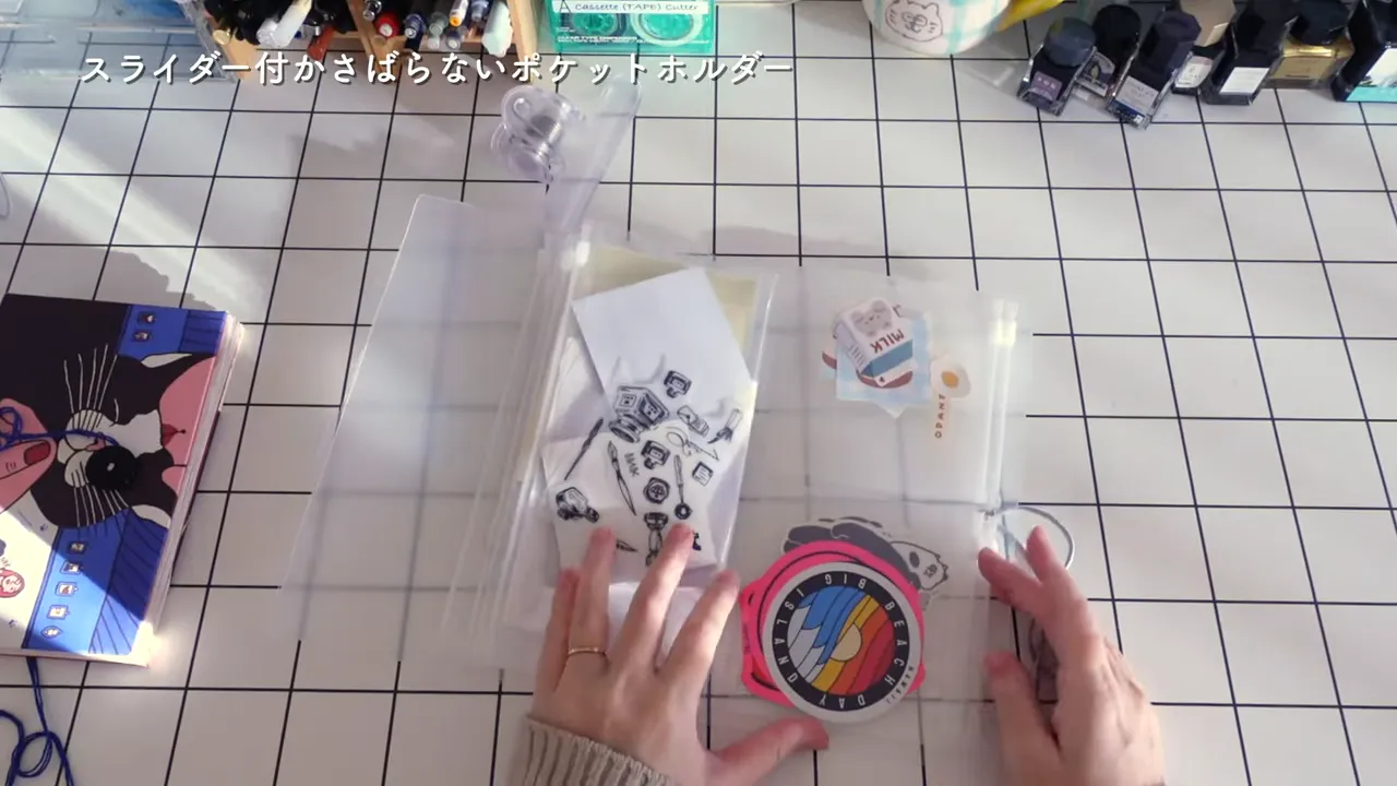 透明ポケットホルダーに色とりどりのステッカーを並べて収納する手元の写真