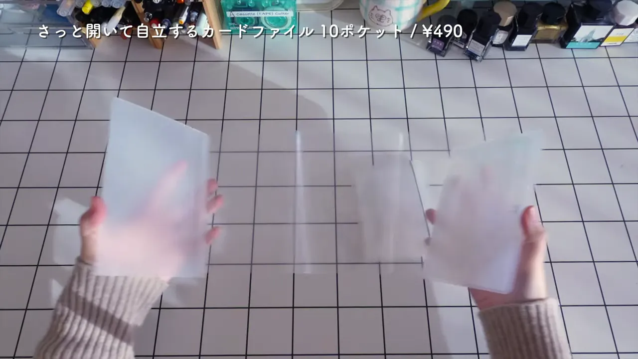 さっと開いて自立するカードファイル(ポストカードサイズ・10ポケット)を両手で広げて見せている写真