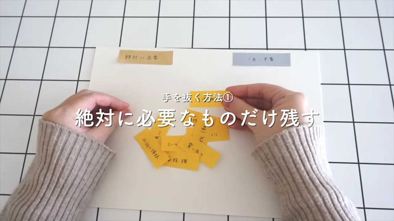 上から見た付箋と両手の手元、付箋を並べて優先度を整理している写真