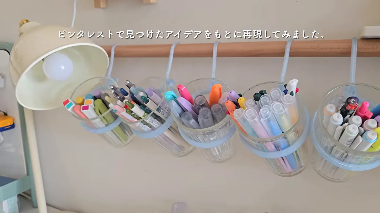 壁掛けペン収納で、ガラスコップに入った色とりどりのペンが見渡せる様子