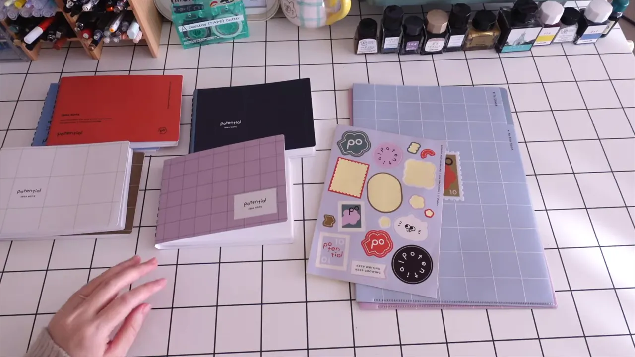 複数のPotentialノート、シール、A4ファイルが格子柄のデスクに並ぶ俯瞰写真