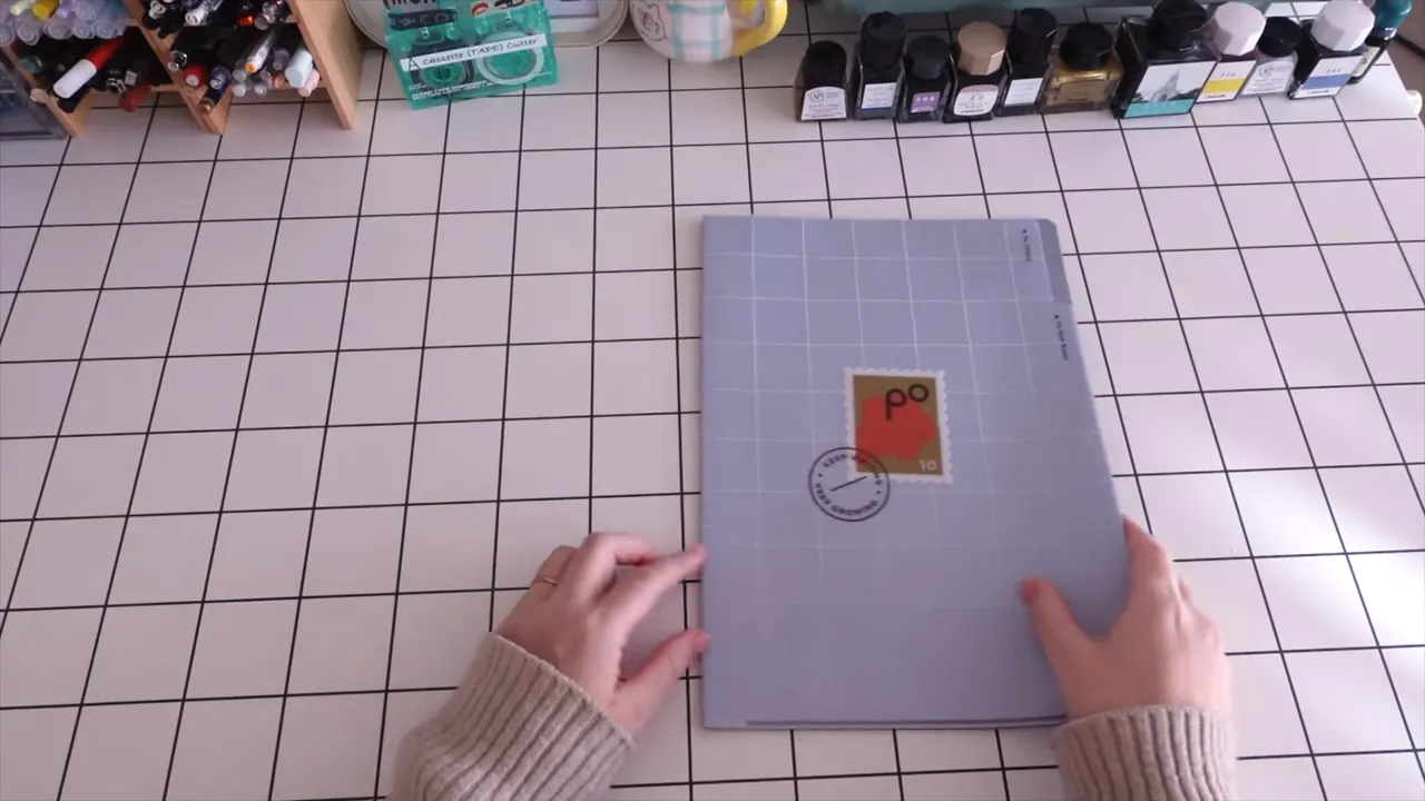 A4サイズの2ポケットクリアファイルをテーブル中央に置き、右手がファイルを扱おうとしている俯瞰ショット（シンプルで見やすい）