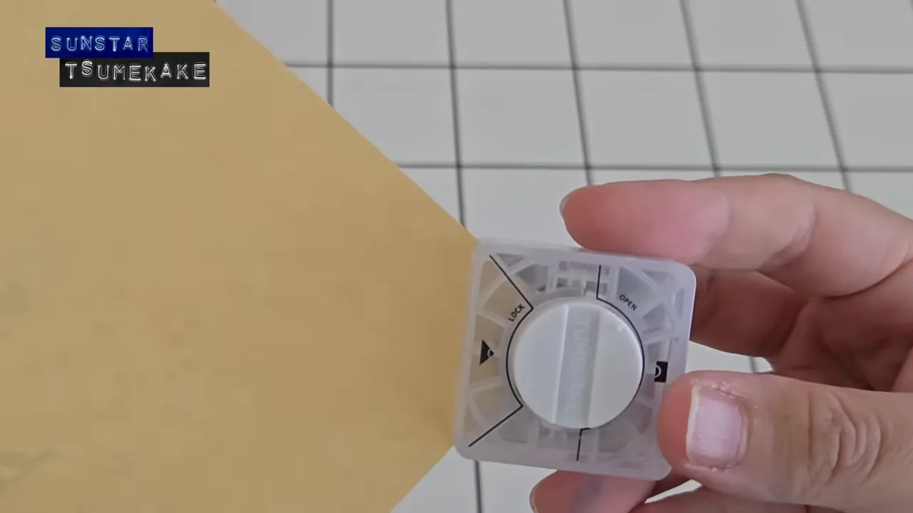 サンスター文具 ツメカケ を紙に合わせて差し込む様子（透明ボディ）