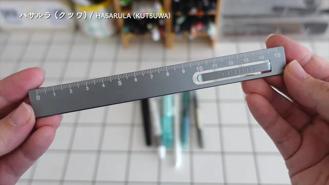 金属製の15センチ定規の目盛り部分を両手で持って見せている