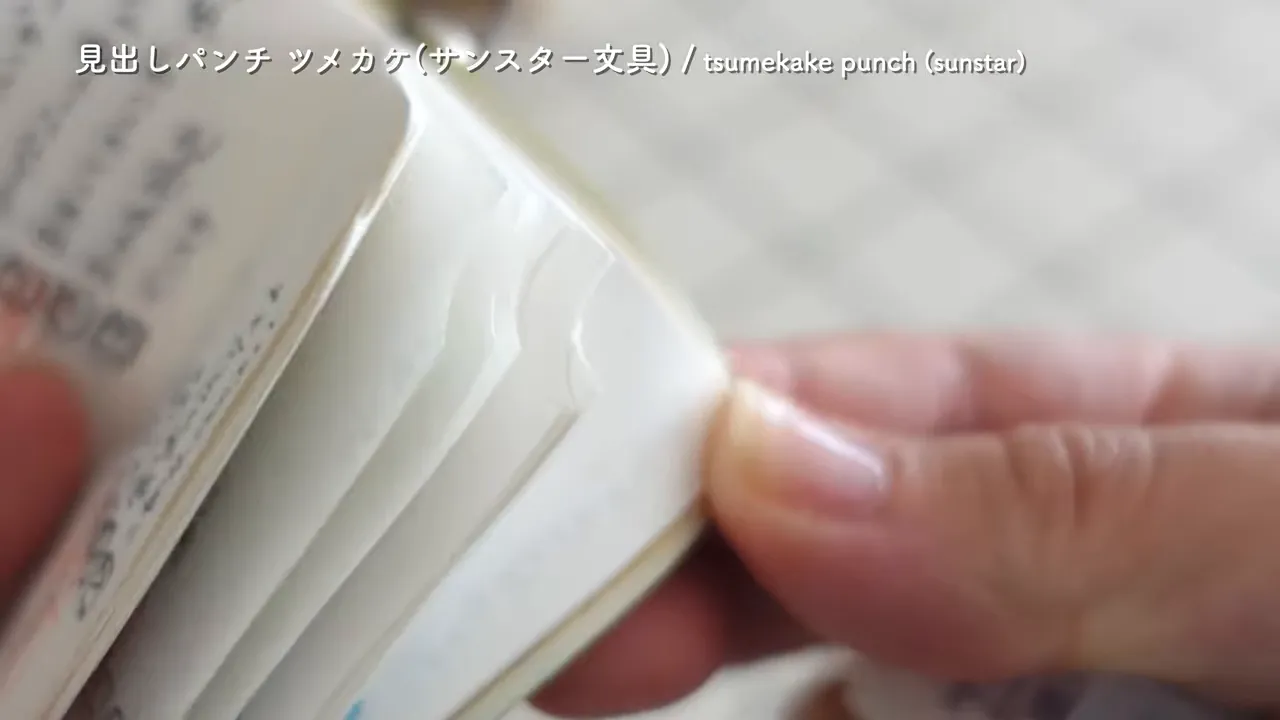 ノートのページ端に付けた切り欠きに指を掛けてページをめくっている