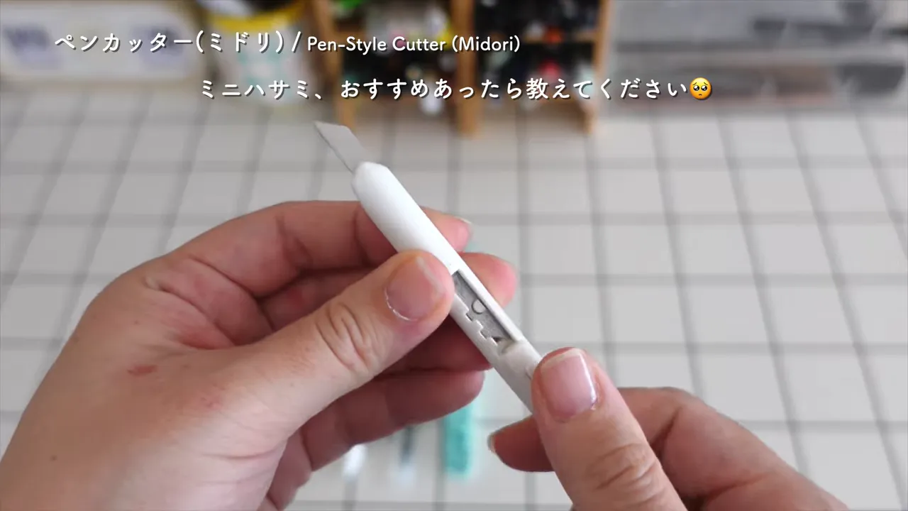 白い持ち手のペン型カッターの刃を少し出して見せている
