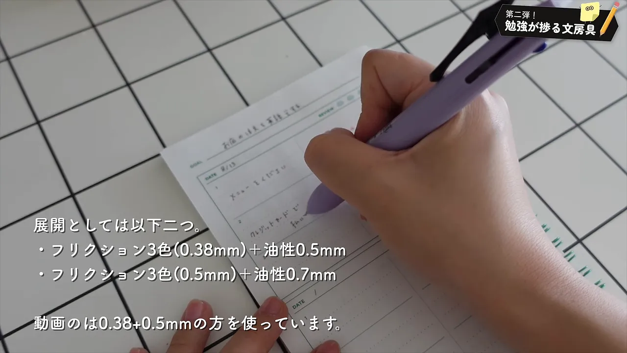 紫色の多機能ペンでレビューノートに書き込む手元