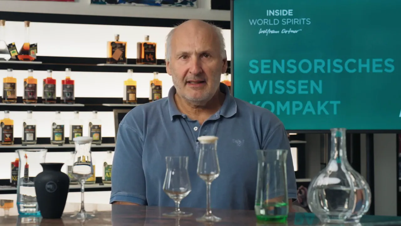 Verkostungsgläser, Messgefäße und Dekanter auf einem Tisch, im Hintergrund ein Display mit 'Sensorisches Wissen Kompakt'.