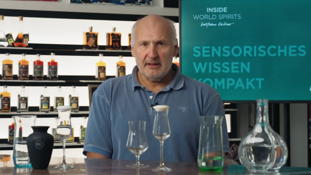 Moderator erläutert Aromaprofile von Rum; Verkostungsgläser und Dekanter im Vordergrund