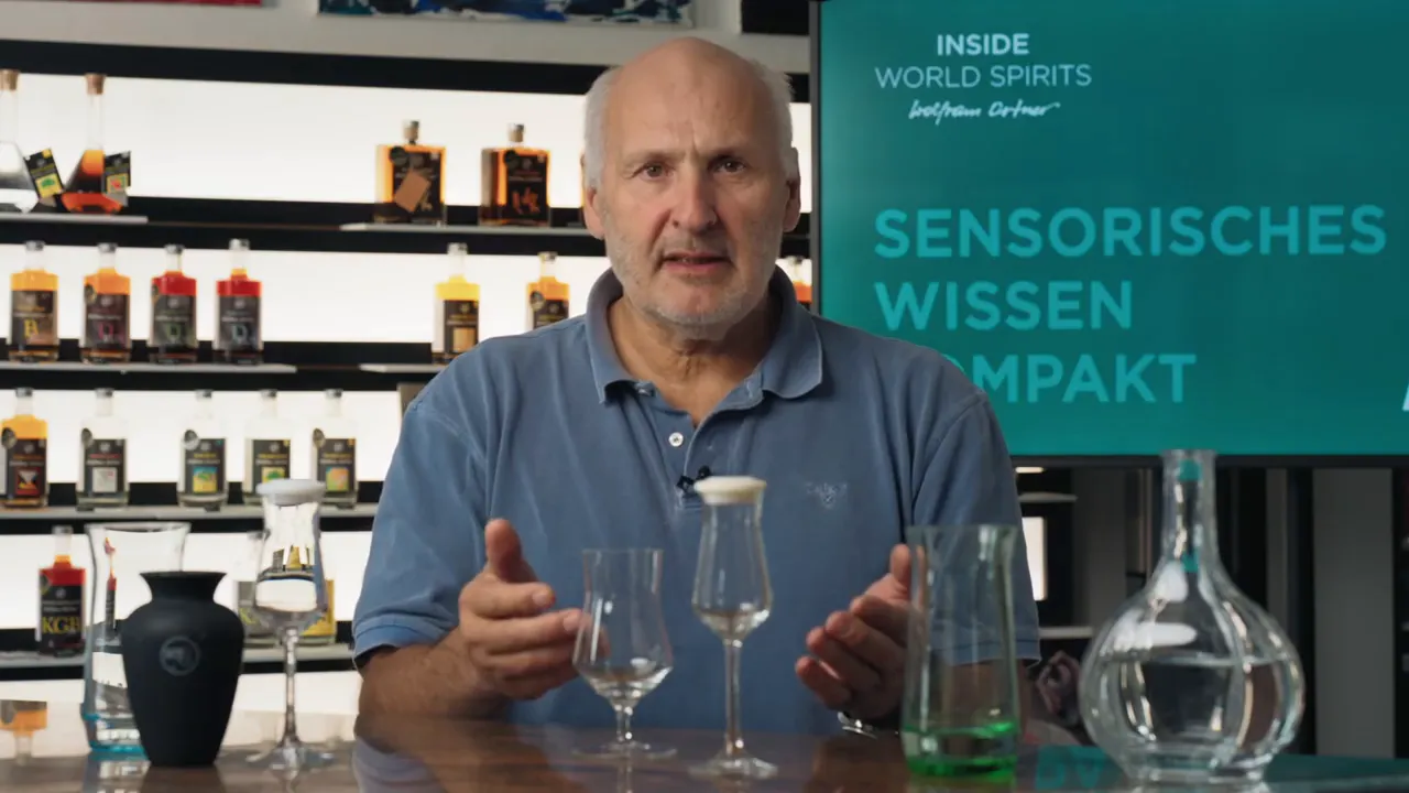 Experte demonstriert Sensorik mit Glas und Destillatflasche vor der Bühne