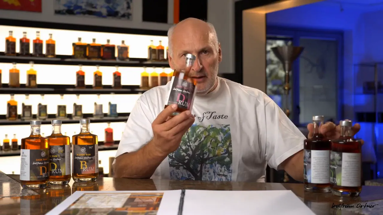 Person presenting a rum bottle to camera with a lineup of other released bottles on the counter and illuminated shelves behind.