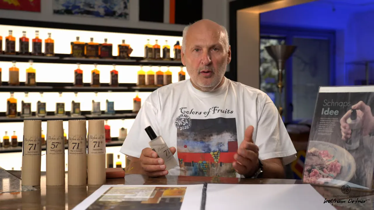 Moderater Shot: Mann erklärt Parfum de Vie 71, mehrere verpackte Varianten links sichtbar