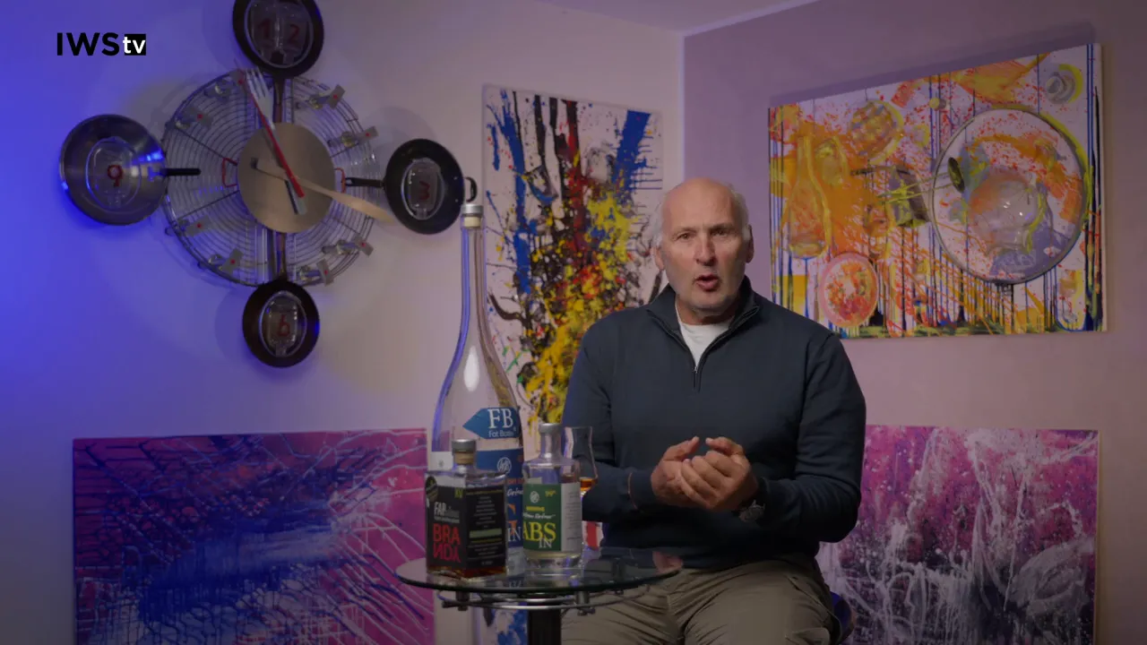 Experte erklärt das Aromaprofil des Brombeergeists; Flasche und Verkostungsglas sind im Vordergrund gut sichtbar