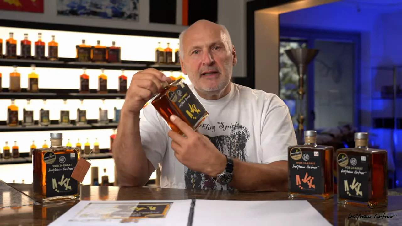 Moderator zeigt WOB 24 Karat Flasche vor Regal mit weiteren Abfüllungen