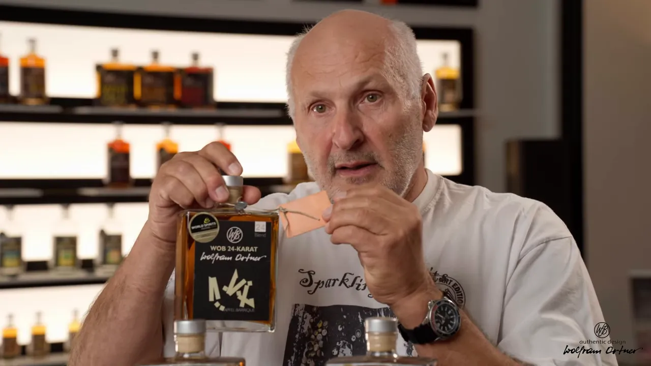 Nahaufnahme einer WOB 24 Karat Flasche mit personalisiertem Anhänger in der Hand