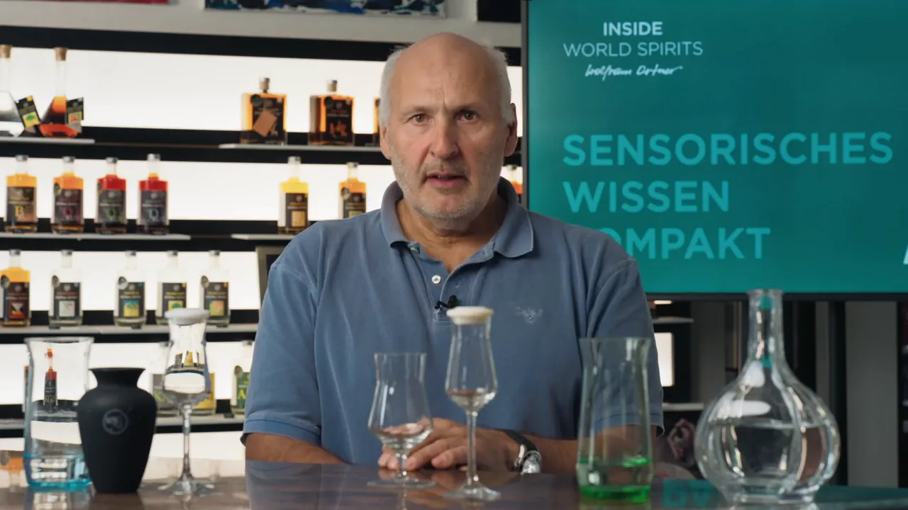 Tasting‑Setup mit Nosing‑Gläsern, Dekanter und Spirituosenregal zur Verdeutlichung von Meeres‑ und Torfnoten