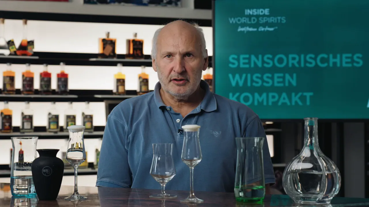 Tisch mit verschiedenen Gläsern, Karaffen und Verschlüssen vor Moderator und Infotafel