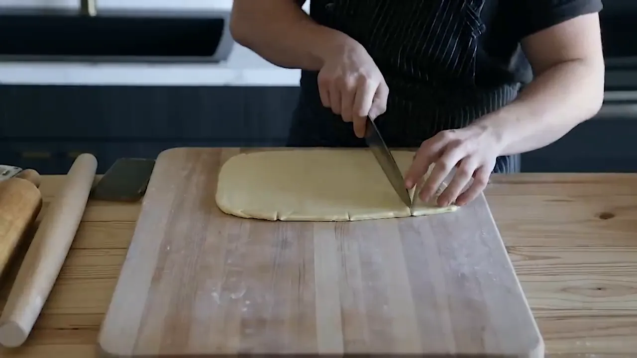 Cutting dough into croissant triangles