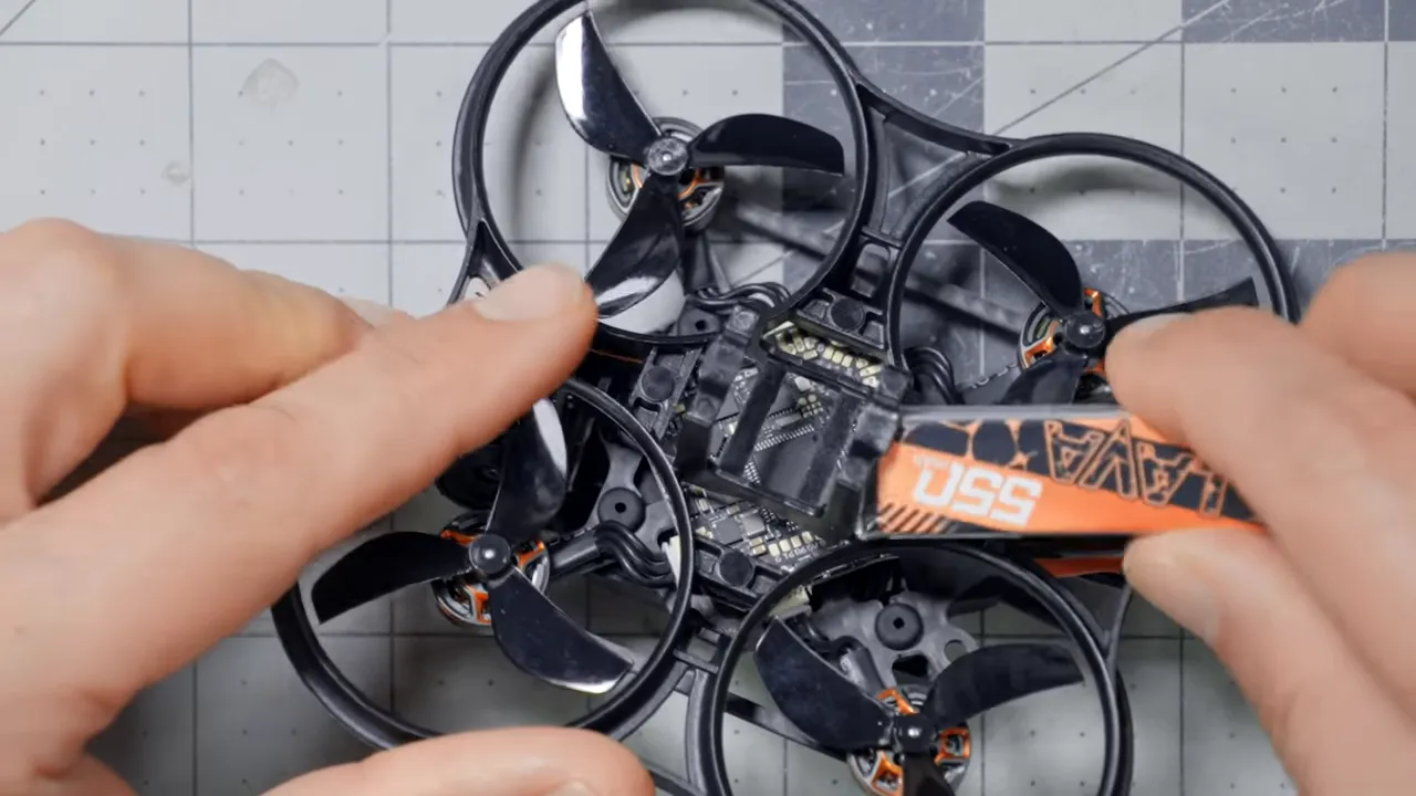 Top-down close-up of Pavo Pico II internals with battery being removed, showing flight controller and battery tray