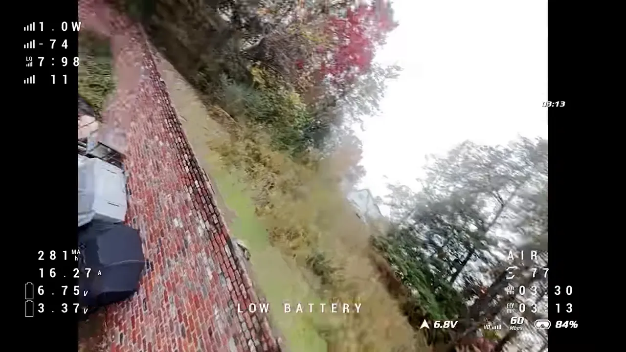 Pavo Pico II aggressive bank with 'LOW BATTERY' telemetry overlay showing steep tilt and motion