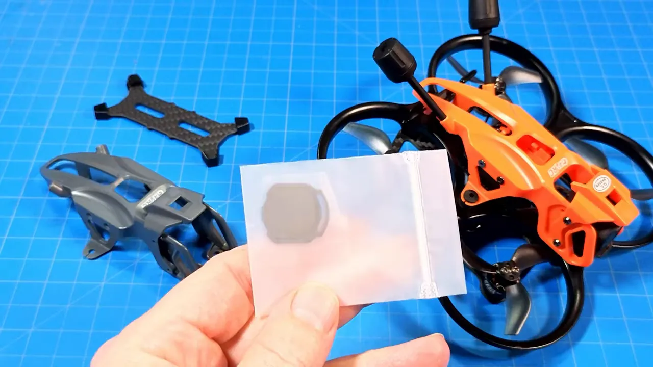 Unboxed DarkStar22 O4 Pro canopy alongside a spare carbon plate and a small bag containing a rubber damper on a blue work mat.