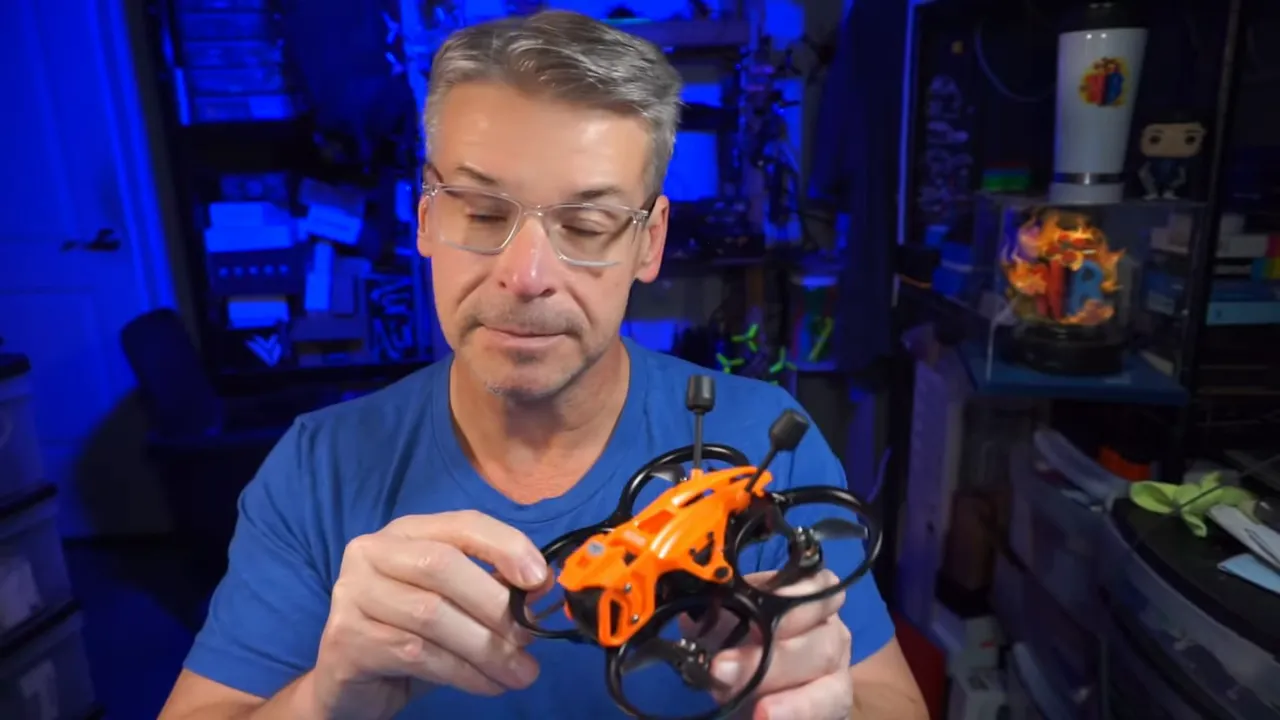 Host holding DarkStar22 O4 Pro micro whoop with orange floating canopy and ducted prop guards
