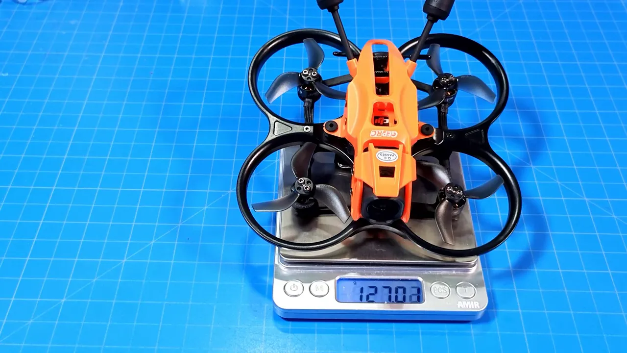 DarkStar22 O4 Pro micro whoop sitting on a digital scale showing 127.03 grams