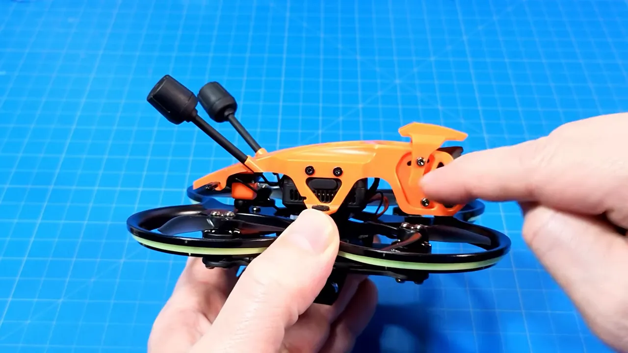 Finger pointing at the DarkStar22 orange canopy screw area showing where to loosen the hood to change camera angle