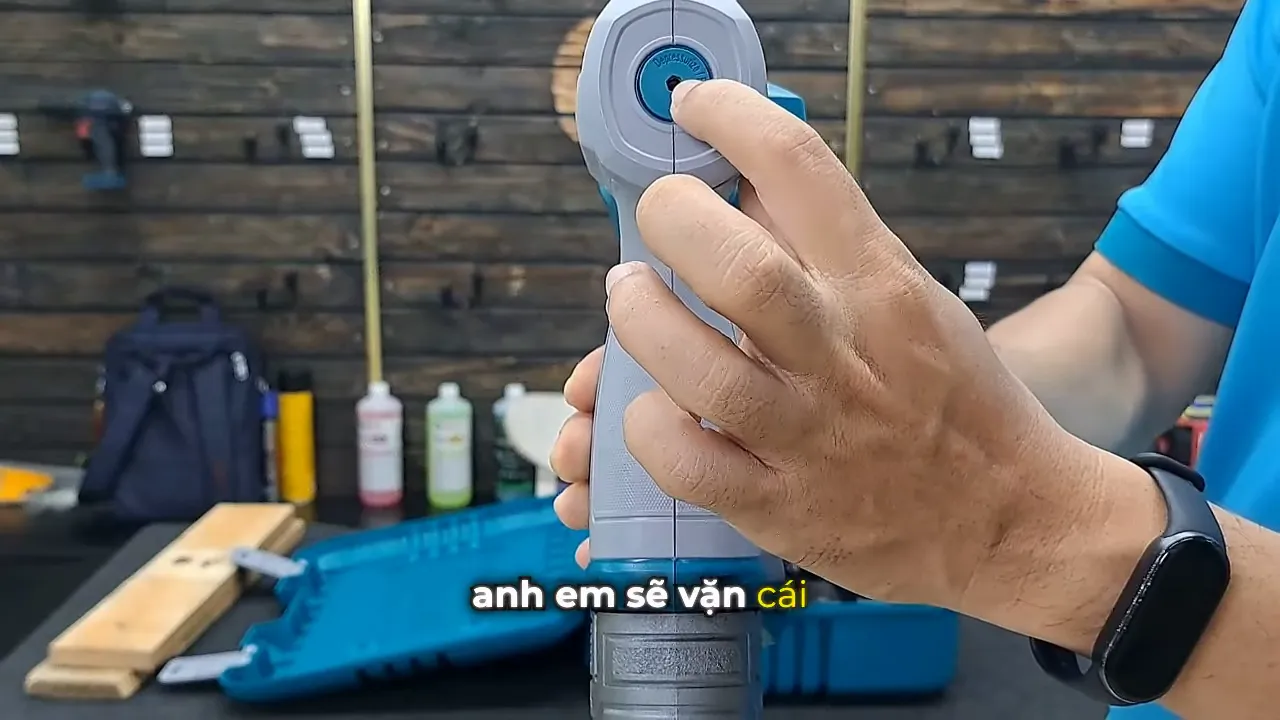 Người dùng chỉ vào nắp van tích hơi trên thân máy bắn đinh Total