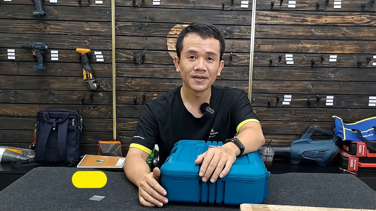 Hộp dụng cụ Total màu xanh rõ nét trên bàn, logo TOTAL nhìn thấy, người giới thiệu ngồi cạnh.