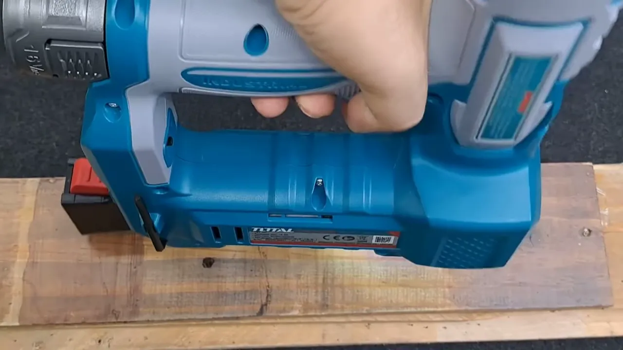 Cận cảnh máy bắn đinh Total TCBNLI2038 đặt trên miếng gỗ pallet, thể hiện vị trí tiếp xúc khi thử bắn