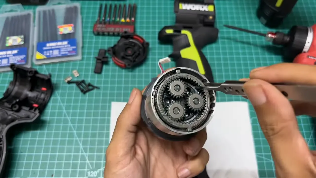 Cận cảnh ba bánh răng hành tinh bên trong hộp số Worx WU138 với nhíp đang chạm vào