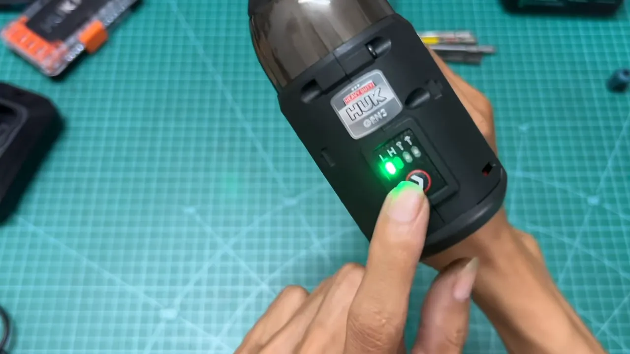 Cận cảnh nút chọn chế độ Hucan Gen3 với đèn LED màu xanh, ngón tay đang bấm