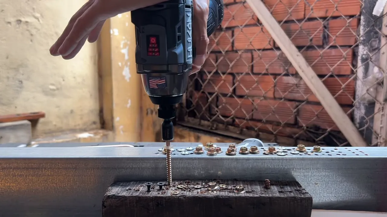 Hucan Gen3 đang siết vít vào khung thép với tay điều khiển