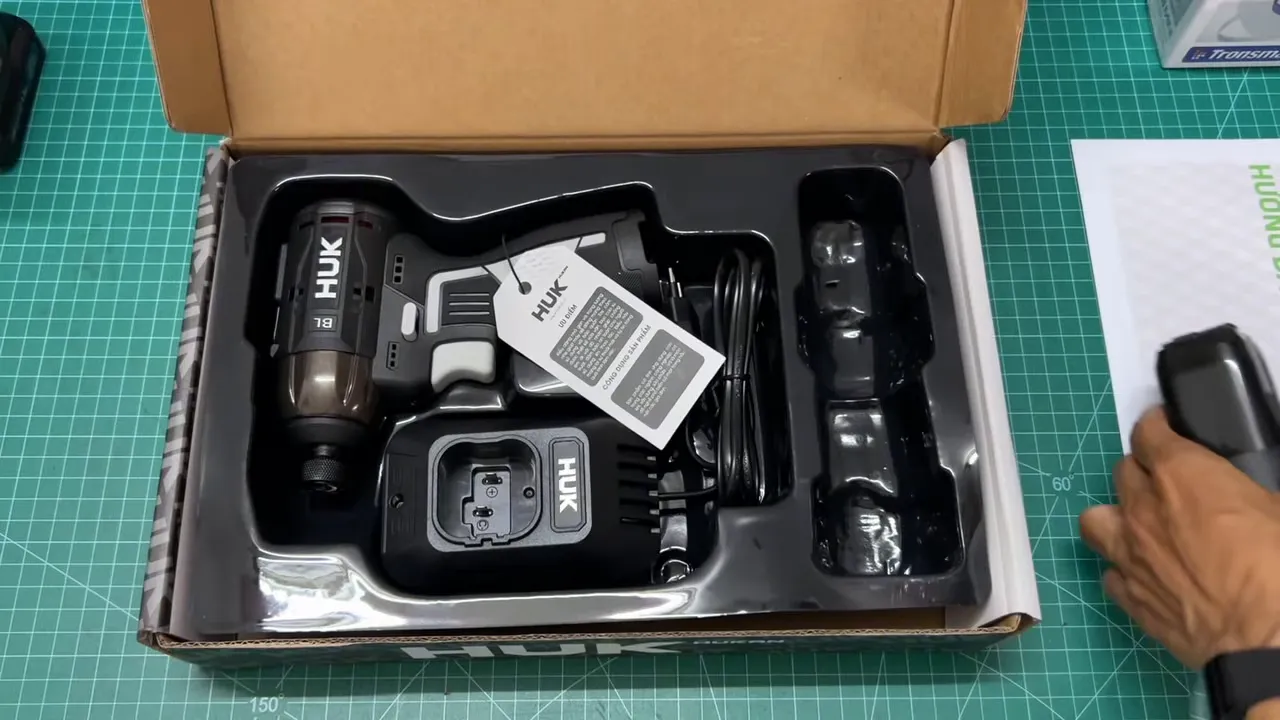 Hucan Gen 3 16V nằm trong hộp kèm đế sạc và ngăn pin, nhìn từ trên