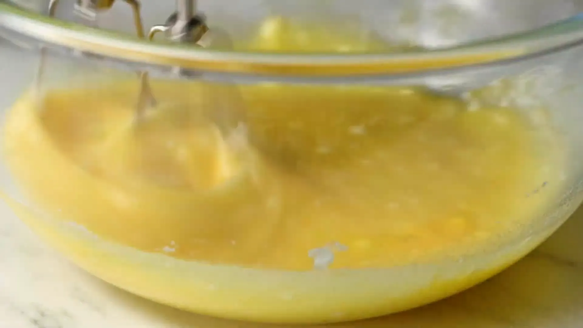 Mixing bowl with batter and blueberries being folded in