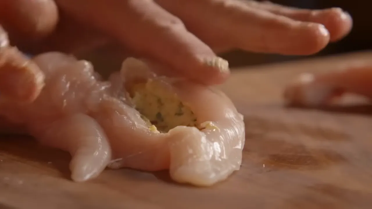 Chicken breast pocket being filled with garlic and parsley compound butter for Chicken Kyiv.