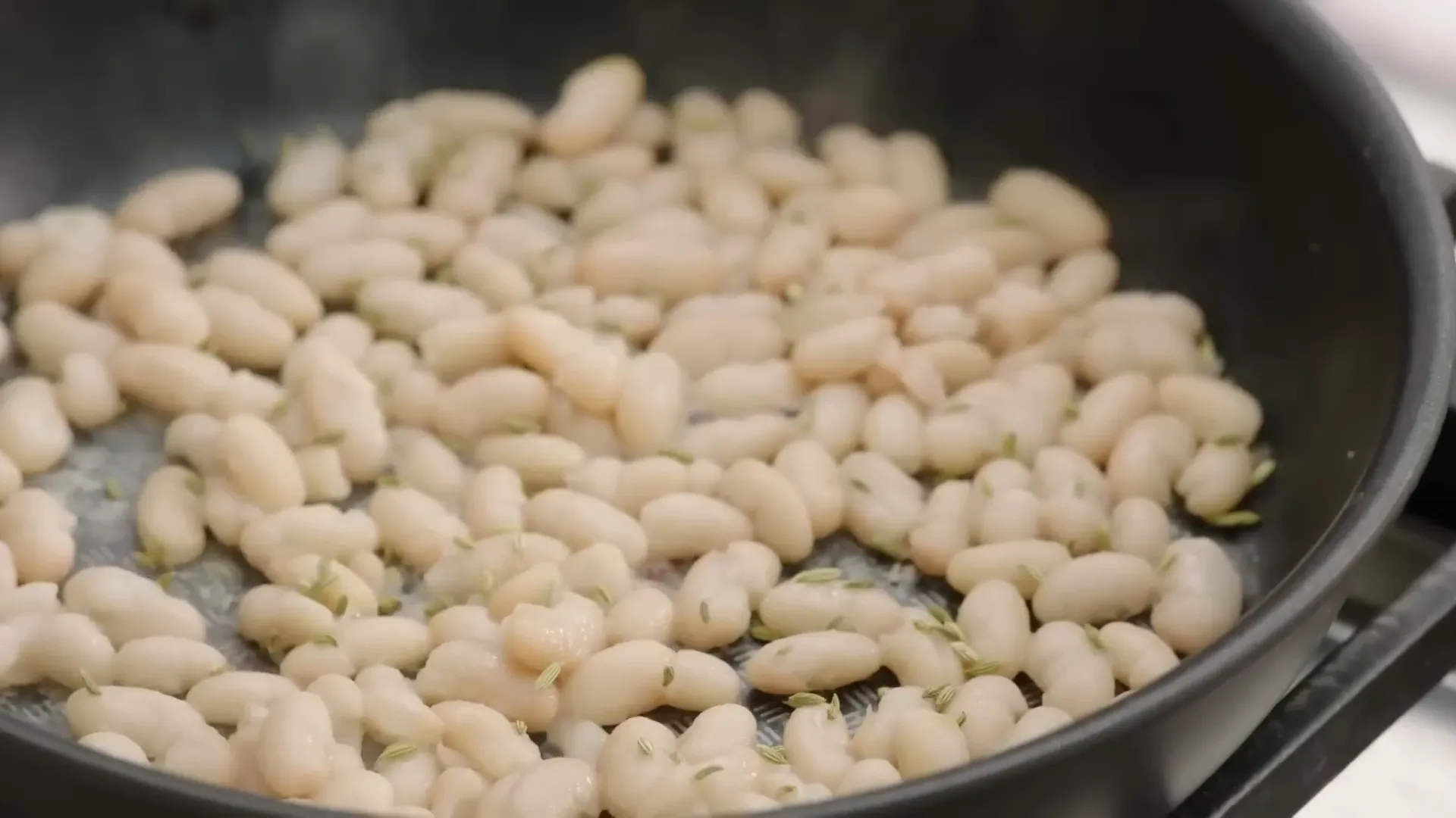 Crisping cannellini beans in the pan with fennel seeds